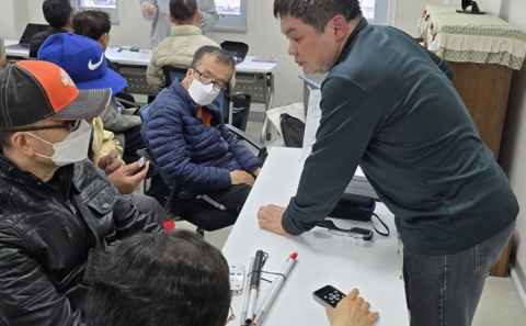 경기도시각장애인복지관 담당자가 아이폰 사용 방법을 설명하고 있다